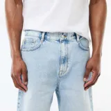 Bermudas de denim de corte clásico en color celeste claro, con bolsillos laterales y traseros, y cierre frontal con botón y cremallera.