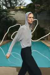 Sudadera de punto con hilo metalizado color gris, con capucha, manga larga y cierre frontal con cremallera.