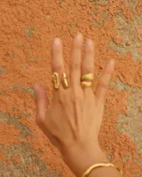 Anillo de diseño abierto con textura escamada que simula la piel de una serpiente, elaborado artesanalmente en metales nobles.