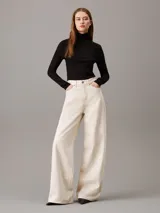 Top negro de modal elástico con estructura de canalé, diseño ajustado, cuello alto y mangas largas.