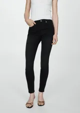 Pantalón de jean estilo skinny, de tiro alto, color negro, con cierre de cremallera y botón, y diseño de cinco bolsillos.