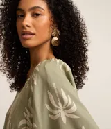 Blusa verde militar con estampado de cocoteros en tono claro, de mangas corta tipo godê y escote cuadrado con detalles fruncidos.