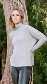 Sweater negro de tejido de punto, con cuello alto y mangas largas con puños acanalados.