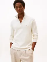 Sweater de punto color blanco marfil de la marca Tommy Hilfiger, con cuello perkins y cierre frontal parcial de cremallera. Presenta mangas largas con puños de canalé y el logo bordado en el pecho.