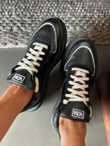 Championes blancos de cuero con cordones y apliques metálicos.