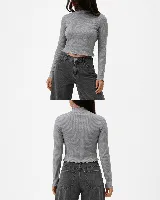 Remera de morley de algodón gris, con cuello alto, manga larga y terminaciones con borde fruncido en cuello, puños y ruedo.