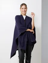 Ruana negra de tejido suave, con cierre frontal de botones metálicos y ribetes de cuero sintético en los bordes.