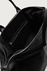 Bolso de viaje tipo bowling fabricado en combinación de nylon y detalles en cuero sintético, de color negro. Cuenta con compartimento principal con cierre de cremallera, bolsillo frontal plano, dos asas de mano y un asa de hombro ajustable y extraíble.