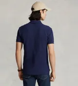 Remera polo Ralph Lauren de corte clásico, color azul marino con el logo del jinete bordado en rojo en el pecho. Cuenta con cuello y puños acanalados, y tapeta corta con botones.