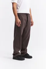 Pantalón de algodón de corte recto y estilo relajado, color beige. Cuenta con cintura elástica con cordón de ajuste, bolsillos laterales y logo de la marca estampado discretamente en el frente.