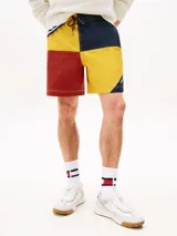 Shorts de nailon con diseño color block en rojo, amarillo y azul marino. Cuenta con dos bolsillos en la cintura y logo de Tommy Hilfiger en el bajo y la parte trasera.