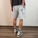 Short de algodón gris melange con cintura elástica y cordón de ajuste, de corte holgado y ruedo sin costura.