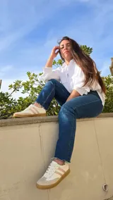 Zapatillas Dallas de cuero blanco, con detalles en gamuza beige y tiras laterales rosadas, suela de goma y diseño urbano.