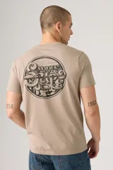 Remera de manga corta color beige, con cuello redondo y un pequeño estampado gráfico en el pecho.