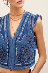 Chaleco de denim azul de corte ajustado, con cuello en V y elaborados bordados decorativos en contraste.