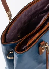 Cartera azul de cuero sintético con doble asa corta color marrón. Tiene dos compartimentos principales con cierre y bolsillos internos. Incluye correa larga extraíble.