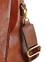 Cartera de mano de cuero sintético con acabado charol y textura de piel de reptil en color tostado. Cuenta con doble asa rígida superior, herrajes dorados y correa ajustable y removible.