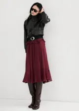 Vestido largo bordó de poliéster, de corte oversize, con escote en V y detalle de volantes en la cintura y el canesú. Cuenta con mangas largas y forro interior.