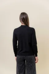 Buzo de tejido fino color amarillo claro, con cuello semi alto, manga larga y calce regular.