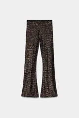 Pantalón de tiro alto con corte flare, confeccionado con aplicación de lentejuelas en toda la prenda y cintura elástica.