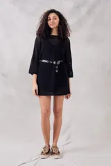 Minivestido negro de calados con mangas 3/4 y cinturón con hebilla metálica.