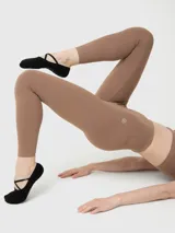 Calza deportiva de tiro alto con largo hasta el tobillo, confeccionada en tejido suave con tratamiento de aloe vera. Presenta un diseño liso con costuras reforzadas y logo pequeño en la cadera.