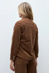 Camisa de pana color tostado, con cuello clásico, cierre frontal con botones metálicos y bolsillos frontales con solapa.