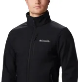 Campera softshell Columbia modelo Ascender, color negro, con tecnología Omni-Shield repelente al agua y cortavientos. Presenta cuello alto con protector de mentón, cierre frontal completo, bolsillo en el pecho y bolsillos laterales con cremallera, además de puños y dobladillo ajustables.