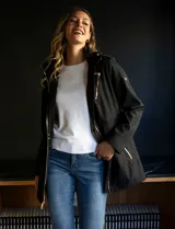 Campera liviana negra marca Michael Kors, con cierre metálico dorado, bolsillos delanteros con cierre, cintura ajustable con jareta interna, capucha desmontable y avíos metálicos dorados con logo.