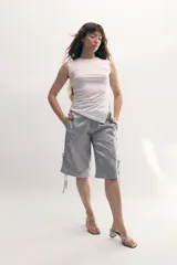 Bermuda gris satinada con corte recto, cintura elastizada, bolsillos frontales y tiras laterales para ajustar.