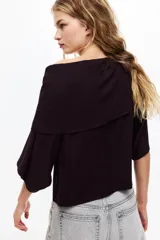 Top corto color bordó en punto elástico de viscosa, con escote bote, hombros caídos, mangas cortas amplias y sección superior superpuesta con diseño asimétrico efecto capa.