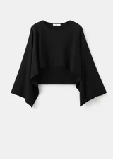 Poncho negro de diseño asimétrico, con cuello redondo y mangas amplias tipo capa.