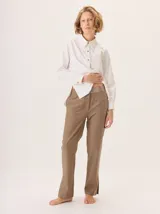Pantalon de corte cigarrillo con pierna angosta, confeccionado en una mezcla de algodon y tencel. Presenta un diseño minimalista con detalles de costura en contraste y una pequeña abertura en el ruedo.