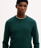 Suéter básico de punto color verde oscuro, de manga larga, con cuello redondo y puños y bajo acanalados.