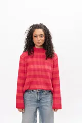 Buzo de tejido de punto con cuello alto, manga larga y diseño a rayas horizontales en tonos fucsia y naranja.