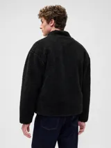 Canguro de polar negro con cierre frontal, cuello alto y bolsillo en el pecho con cierre y logo de la marca bordado.