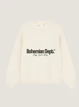 Sweater de hilo color blanco roto, con cuello redondo, manga larga y puños y dobladillo acanalados. Presenta un estampado frontal con el texto "Bohemian Dept.® Only Good News" en negro.