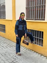 Pantalón cargo de jean y tela negra, con bolsillos laterales y corte holgado.