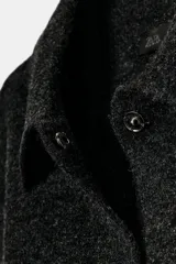 Chaqueta de punto texturizado en color gris oscuro, con cuello solapa, manga larga con puños elásticos y cierre frontal con botones.