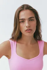 Top deportivo cropped de color rosado con escote corazón y soutien incorporado, confeccionado en tejido funcional con tecnología SculptMove™ y DryMove™.