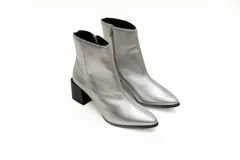 Botas cortas plateadas de cuero con punta fina y cierre lateral. Taco geométrico color negro.
