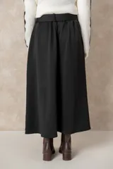 Pollera midi de corte acampanado y tiro alto, con diseño plisado en la cintura y bolsillos laterales. Confeccionada en tela de textura suave color beige.