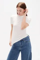 Remera de viscosa con textura acanalada, corte al cuerpo, cuello alto y mangas cortas.
