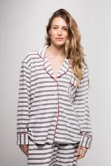 Pijama de tela tipo velvet a rayas horizontales grises y blancas, con vivos en color rojo. Incluye camisa de manga larga con botones frontales y bolsillo en el pecho, y pantalón recto con elástico en la cintura.