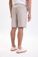 Bermuda clásica color visón de corte recto, con bolsillos laterales y traseros, confeccionada con tejido elástico para mayor comodidad.
