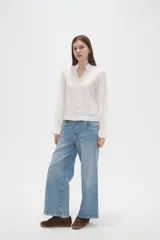 Blusa de viscosa color bordó con diseño bordado geométrico, cuello en V y mangas largas con terminación en volados.