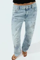 Jeans Z1975 de tiro medio y pernera recta con diseño de cinco bolsillos, cierre frontal con cremallera y botón, y delicado estampado floral en tonos azules.