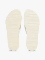 Ojotas blancas con tiras de tejido trenzado y una pequeña insignia con el monograma TH a contraste en la tira del dedo. La suela es de EVA con una línea decorativa azul marino en el borde.