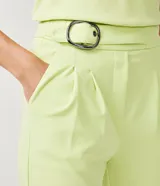 Pantalón zanahoria color verde lima, de crepé con cintura alta, detalle de aro en la cintura y pliegues delanteros.