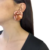 Aros cortos hechos en resina con forma de flores tipo moños de lazo. Se ajustan con perforación y son super livianos. Tienen brillo y volumen que los hacen perfectos para usar de día y de noche.